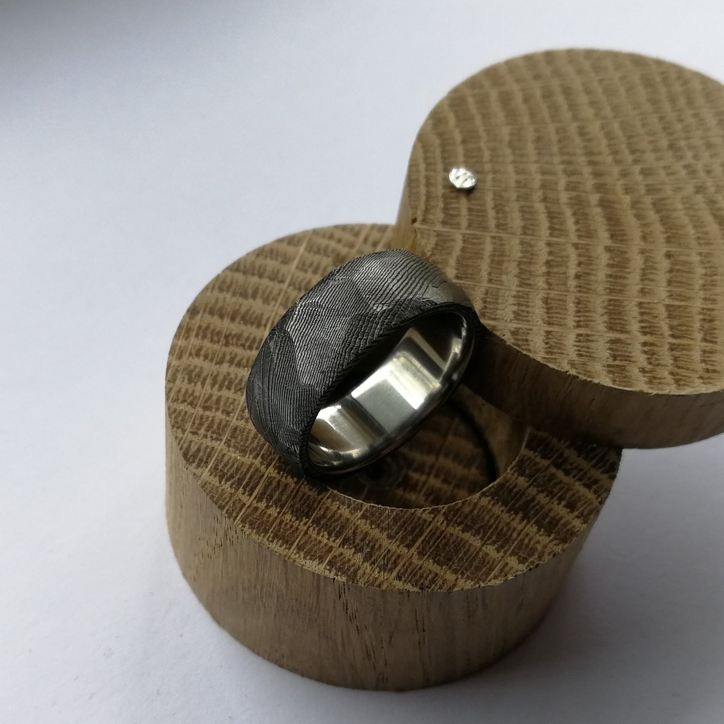 Unique Handmade Faceted Stainless Damascus Steel Ring with Polished Titanium Inner Lining.