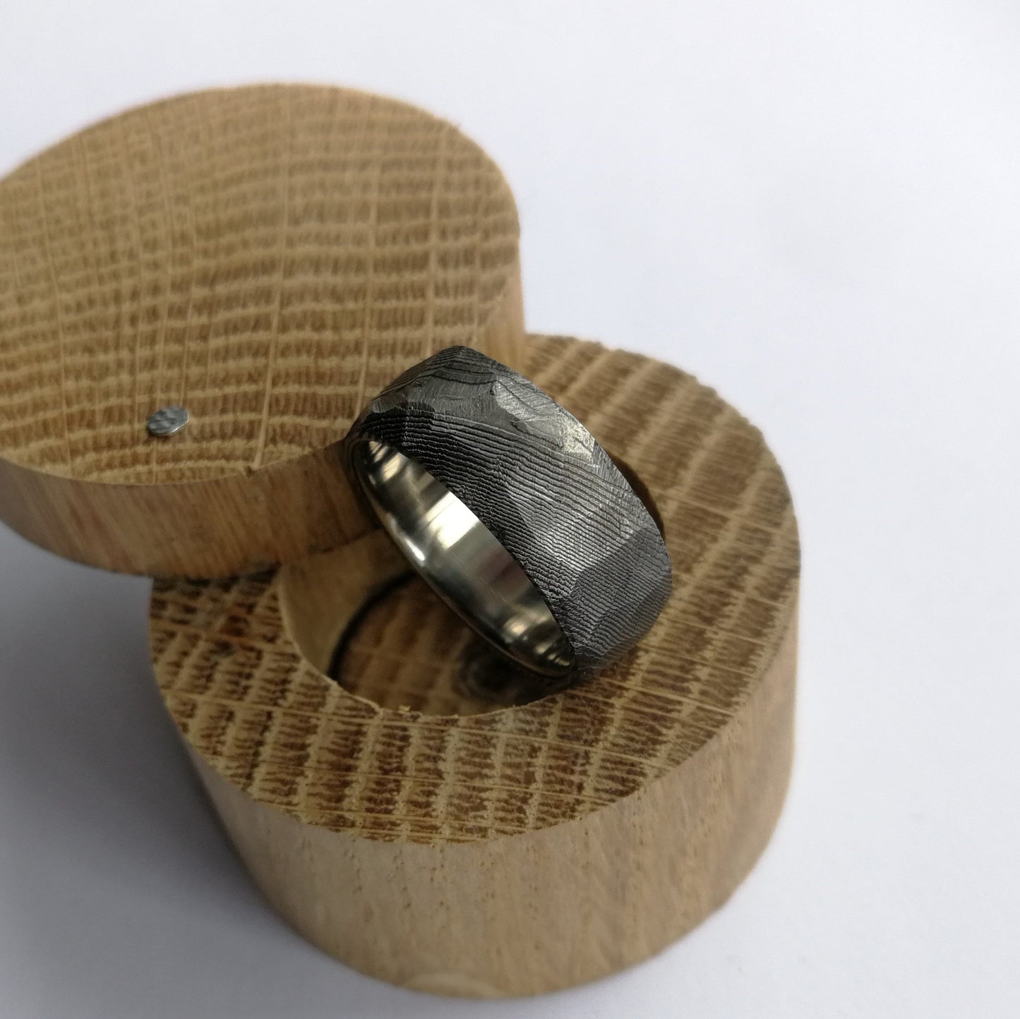 Unique Handmade Faceted Stainless Damascus Steel Ring with Polished Titanium Inner Lining.